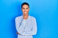 Young african american guy wearing casual clothes looking confident at the camera smiling with crossed arms and hand raised on Royalty Free Stock Photo