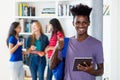 Young african american male student with tablet computer with group of multi ethnic college students Royalty Free Stock Photo