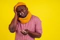 Young african american male wearing red checkered shirt with knitted scarf and hat feeling bad unwell with fever heat Royalty Free Stock Photo