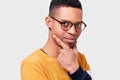 Young African American male wearing sweater and round trandy transparent eyeglasses looking seriously at the camera with pleasant Royalty Free Stock Photo