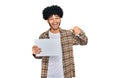 Young african american man with afro hair holding blank empty banner pointing finger to one self smiling happy and proud Royalty Free Stock Photo