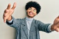 Young african american man with afro hair wearing casual clothes  glasses looking at the camera smiling with open arms for hug Royalty Free Stock Photo