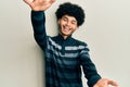 Young african american man with afro hair wearing casual clothes looking at the camera smiling with open arms for hug Royalty Free Stock Photo