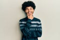Young african american man with afro hair wearing casual clothes looking confident at the camera smiling with crossed arms and Royalty Free Stock Photo