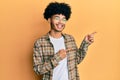 Young african american man with afro hair wearing casual clothes smiling and looking at the camera pointing with two hands and Royalty Free Stock Photo