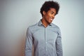 Young african american man with afro hair wearing grey shirt over isolated white background looking away to side with smile on Royalty Free Stock Photo