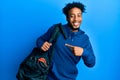 Young african american man with beard holding gym bag smiling happy pointing with hand and finger Royalty Free Stock Photo