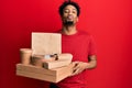 Young african american man with beard holding take away food looking at the camera blowing a kiss being lovely and sexy Royalty Free Stock Photo