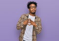 Young african american man with beard wearing casual clothes and glasses hands together and fingers crossed smiling relaxed and Royalty Free Stock Photo