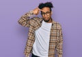 Young african american man with beard wearing casual clothes and glasses pointing unhappy to pimple on forehead, ugly infection of Royalty Free Stock Photo