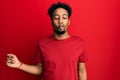 Young african american man with beard wearing casual red t shirt making fish face with lips, crazy and comical gesture Royalty Free Stock Photo