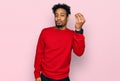 Young african american man with beard wearing casual winter sweater doing italian gesture with hand and fingers confident Royalty Free Stock Photo