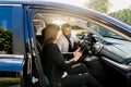 Young African American man communicating with female Caucasian coworker during car drive to business meeting discussing Royalty Free Stock Photo