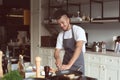 Young African-American man cutting vegetables in restaurant kitchen during cooking classes Royalty Free Stock Photo