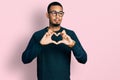 Young african american man doing heart symbol with hands smiling looking to the side and staring away thinking Royalty Free Stock Photo