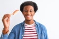 Young african american man eating nigiri using chopsticks over isolated white background with a happy face standing and smiling