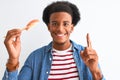 Young african american man eating nigiri using chopsticks over isolated white background surprised with an idea or question