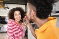 Young African-American man feeding his girlfriend in kitchen Royalty Free Stock Photo