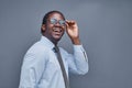 young african american man on a gray background smiling adjusting his glasses Royalty Free Stock Photo