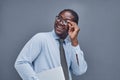 young african american man on a gray background smiling adjusting his glasses Royalty Free Stock Photo