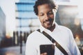 Young African American man in headphone walking at sunny city and enjoying to listen to music on his smart phone.Blurred Royalty Free Stock Photo