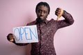 Young african american man holding banner with open word message over pink background with angry face, negative sign showing Royalty Free Stock Photo