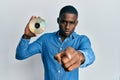 Young african american man holding compact disc pointing with finger to the camera and to you, confident gesture looking serious