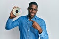 Young african american man holding compact disc smiling happy pointing with hand and finger Royalty Free Stock Photo