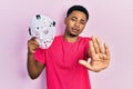 Young african american man holding hockey mask with open hand doing stop sign with serious and confident expression, defense Royalty Free Stock Photo