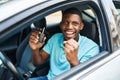 Young african american man holding key of new car with cheerful expression at street Royalty Free Stock Photo