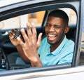 Young african american man holding key of new car with cheerful expression at street Royalty Free Stock Photo