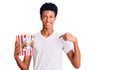 Young african american man holding popcorn pointing finger to one self smiling happy and proud Royalty Free Stock Photo