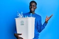 Young african american man holding recycling wastebasket with plastic bottles celebrating victory with happy smile and winner Royalty Free Stock Photo