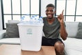 Young african american man holding wastebasket with recycling plastic bottles surprised with an idea or question pointing finger Royalty Free Stock Photo