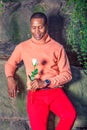 Young African American Man holding white flower, waiting for you Royalty Free Stock Photo