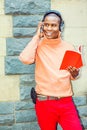 Young African American Man listening Music, reading Book in Cent