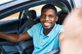 Young african american man making selfie by the camera sitting on car at street Royalty Free Stock Photo