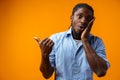 Young african american man pointing at copy space over yellow background Royalty Free Stock Photo