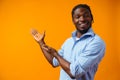 Young african american man pointing at copy space over yellow background Royalty Free Stock Photo