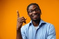 Young african american man pointing at copy space over yellow background Royalty Free Stock Photo