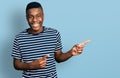 Young african american man pointing with fingers to the side smiling and laughing hard out loud because funny crazy joke Royalty Free Stock Photo