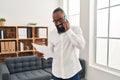 Young african american man psychologist talking on the smartphone at psychology center Royalty Free Stock Photo