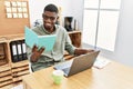 Young african american man reading book working at office Royalty Free Stock Photo