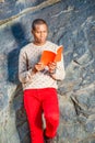 Young African American Man reading red book at park in New York