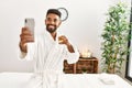 Young african american man relaxed making selfie by the smartphone drinking champagne at beauty center Royalty Free Stock Photo