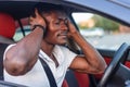 A young African-American man is sitting in the car. Human emotions Royalty Free Stock Photo