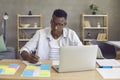 Young african american man sitting at desk working on laptop computer from home Royalty Free Stock Photo