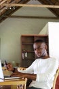 Young african american man sitting at table with mobile phone Royalty Free Stock Photo