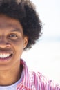 A young African American man smiles brightly outdoors at the beach, unaltered Royalty Free Stock Photo