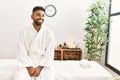 Young african american man smiling happy sitting on massage table at beauty center Royalty Free Stock Photo